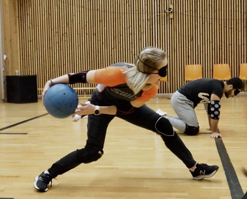 Illustrasjonsbilde fra goalballbanen. En spiller med blindfold forbereder et kast med en ball i en gymsal. Foto: Norges Blindeforbund
