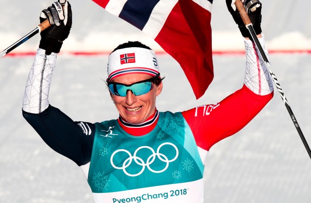 Marit Bjørgen går i mål til gull på 30 km i OL PyeongChang 2018 - som gjorde henne til tidenes mestvinnende olympier. Foto: NTBScanpix