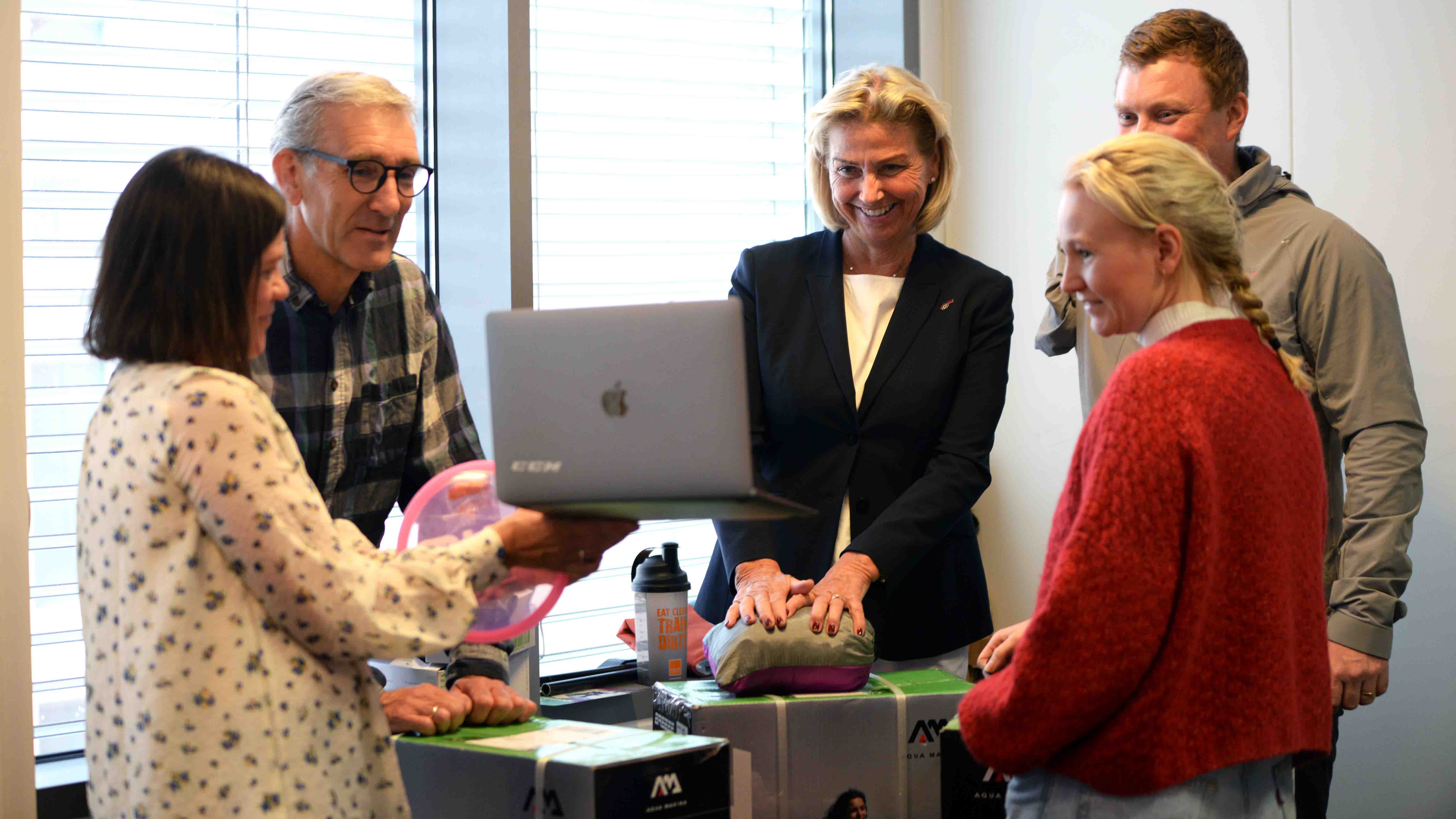 Idrettspresident Berit Kjøll (i midten) overrasket BUA-gjengen på kontoret deres onsdag. Fra venstre: Eline Egeland (faglig leder i BUA), BUA-styreleder Lasse Heimdal, idrettspresident Berit Kjøll, Mads Andreassen (leder for aktivitetsutvikling i Idrettsforbundet) og Anja Lindahl (leder for BUA Digital). Daglig leder i BUA, Monica Vogt, deltok fra PC-skjermen. Foto: Pernille Ingebrigtsen