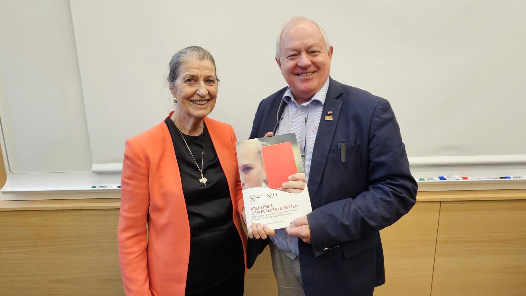 Emerita Kari Fasting overleverer rapporten "Krenkende opplevelser i idretten" til konstituert idrettspresident, Arne Bård Dalhaug. Foto: Geir Owe Fredheim