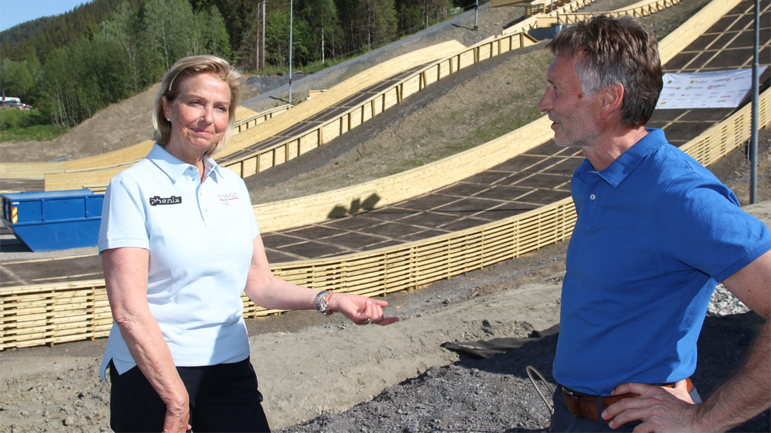 Trond Jøran Pedersen forklarer idrettspresidenten om prosessen fram mot ferdigstillingen av Nord-Norges flotteste hopp-anlegg. Foto: Per Tøien