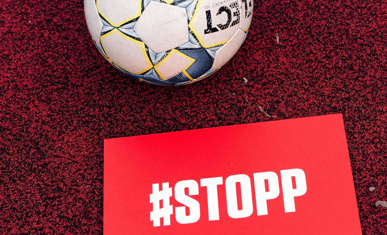 Fotball og #STOPP-plakat.