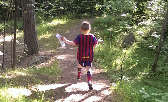 Gutt som løper i skogen