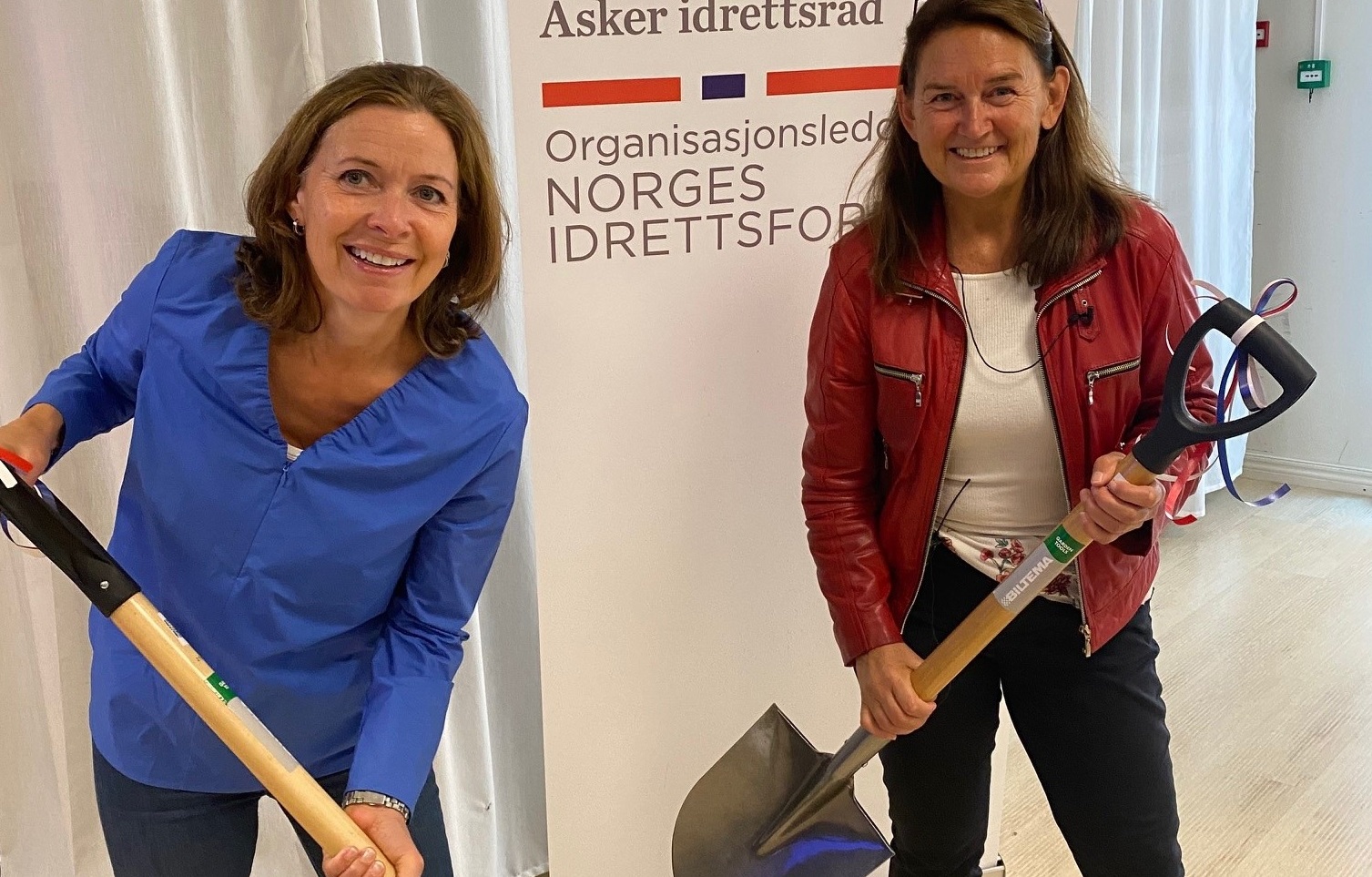 Kari Sofie Bjørnsen (leder hovedutvalg medborgerskap) og Kristin Marie Felde (direktør for medborgerskap i Asker kommune) mottok spade som symbol på anleggsarbeid og dugnad under anleggskonferansen i Asker.